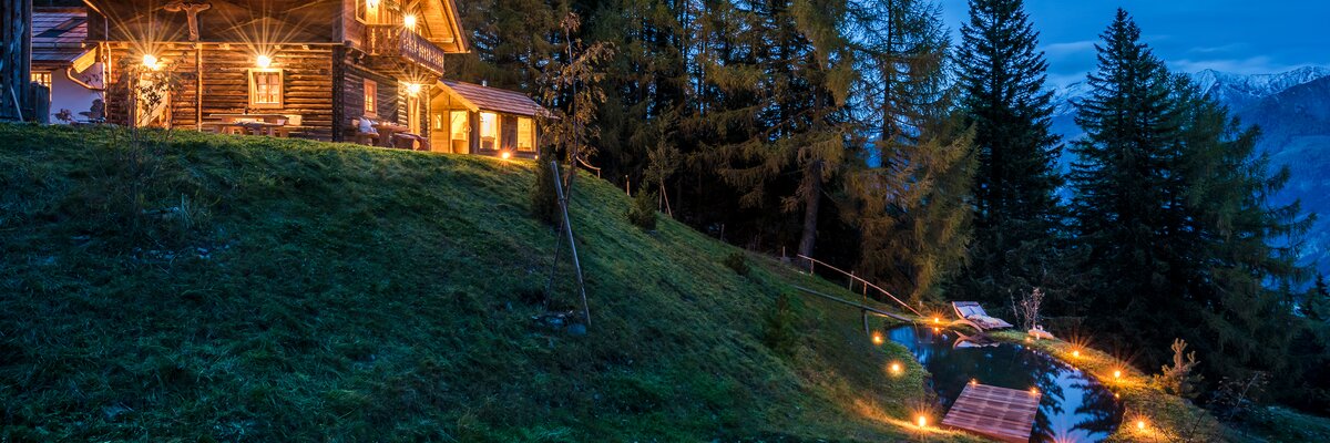 Blick auf Premiumhütte und Teich im Abendlicht  | © Günter Standl