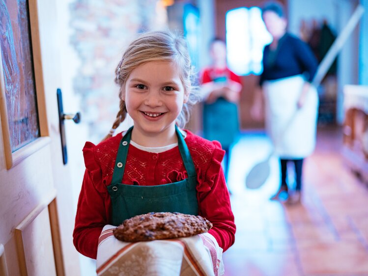 Mädchen holt Brot aus dem Ofen | © Daniel Gollner/ Urlaub am Bauernhof Kärnten