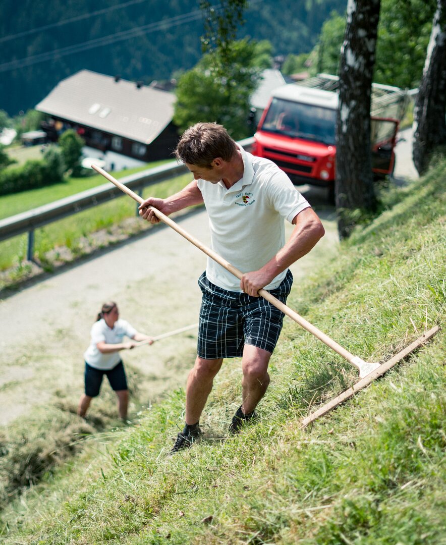 Frau und Mann machen Heu mit Rechen | © Urlaub am Bauernhof Kärnten/ Daniel Gollner