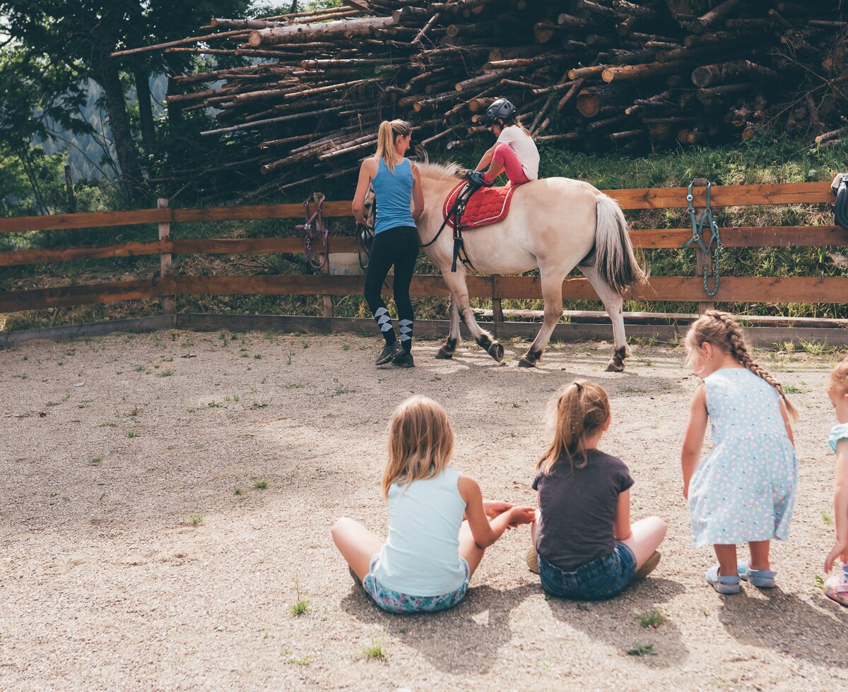 Frau führt Pferd im Viereck und Kinder schauen zu | © Urlaub am Bauernhof Kärnten / Daniel Gollner