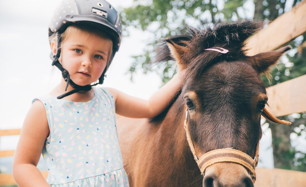 Mädchen streichelt Pony | © Urlaub am Bauernhof Kärnten / Daniel Gollner