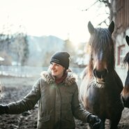 Frau steht mit Pferden im Auslauf | © Urlaub am Bauernhof Kärnten / Daniel Gollner