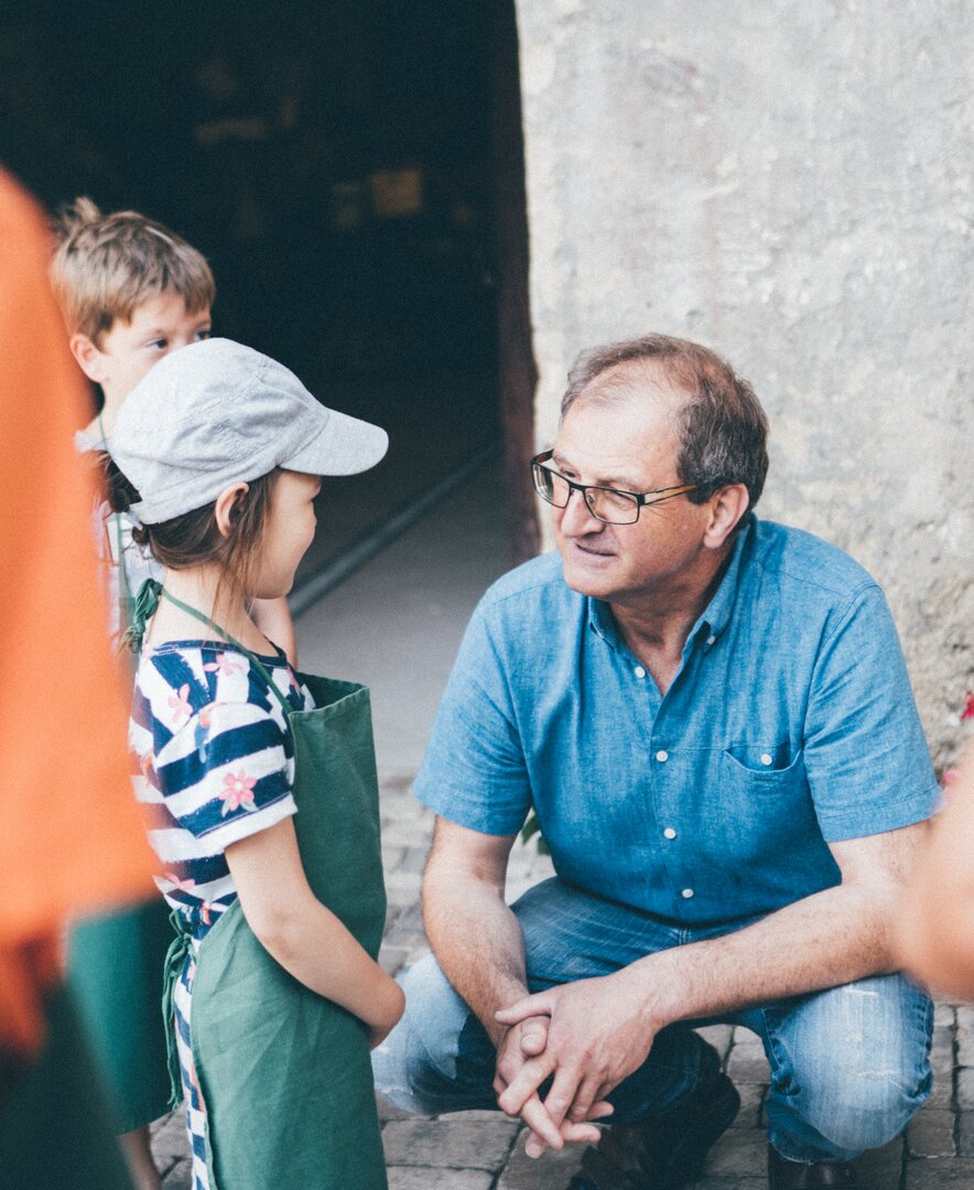 Bauer hockt bei den Kindern | © Urlaub am Bauernhof Kärnten / Daniel Gollner