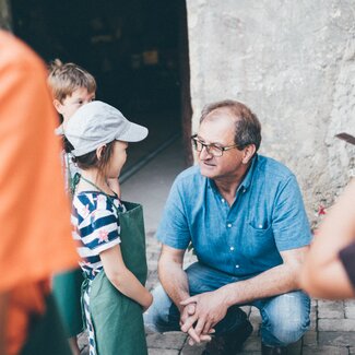 Bauer hockt bei den Kindern | © Urlaub am Bauernhof Kärnten / Daniel Gollner