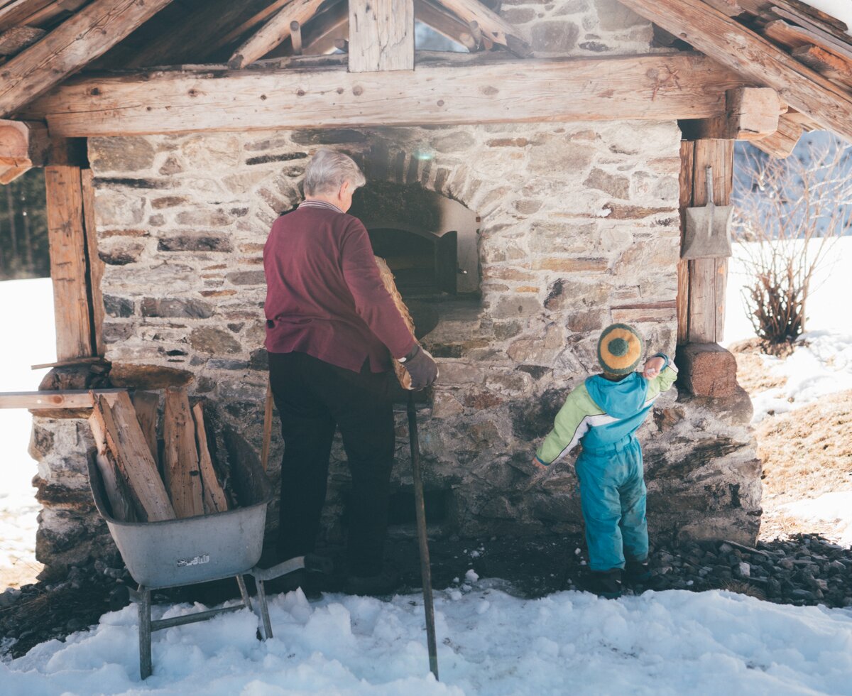 Bäuerin und Kind stehen beim Ofen | © Urlaub am Bauernhof Kärnten / Daniel Gollner