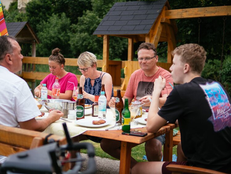 Familie sitzt gemeinsam beim Grillabend | © Urlaub am Bauernhof / Daniel Gollner