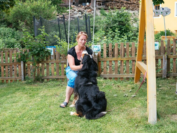 Urlauberin streichelt den Hund des Lacknerhofs | © Urlaub am Bauernhof / Daniel Gollner