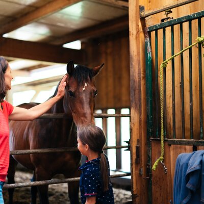 Frau und Kind stehen beim Pferd | © Urlaub am Bauernhof Kärnten/ Daniel Gollner