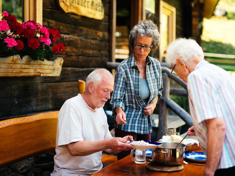 Menschen essen Schwammerl Gulasch auf der Gartengarnitur | © Urlaub am Bauernhof Kärnten/ Daniel Gollner