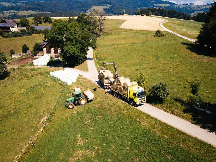 Traktor und LKW beim Heuballen abladen | © Urlaub am Bauernhof Kärnten / Daniel Gollner