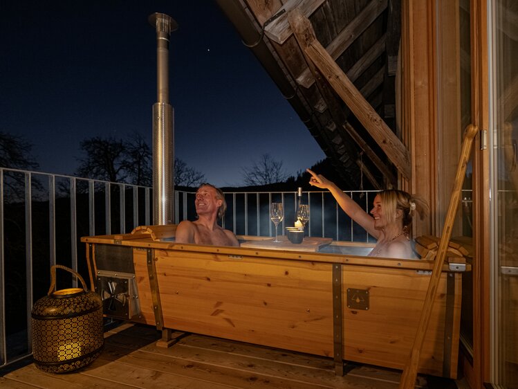 Paar sitzt in der Holzwanne am Balkon | © Urlaub am Bauernhof Kärnten/ Achim Mandler