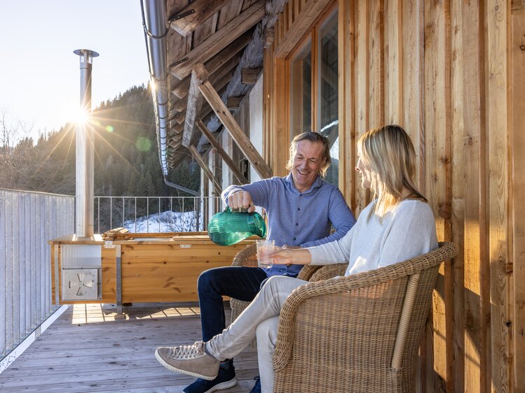 Paar sitzt am Balkon und trinkt Wasser | © Urlaub am Bauernhof Kärnten/ Achim Mandler