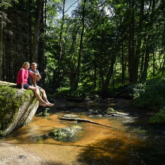 Paar sitzt auf Stein bei einem Flussbett im Waldviertel | © Waldviertel Tourismus / Robert Herbst