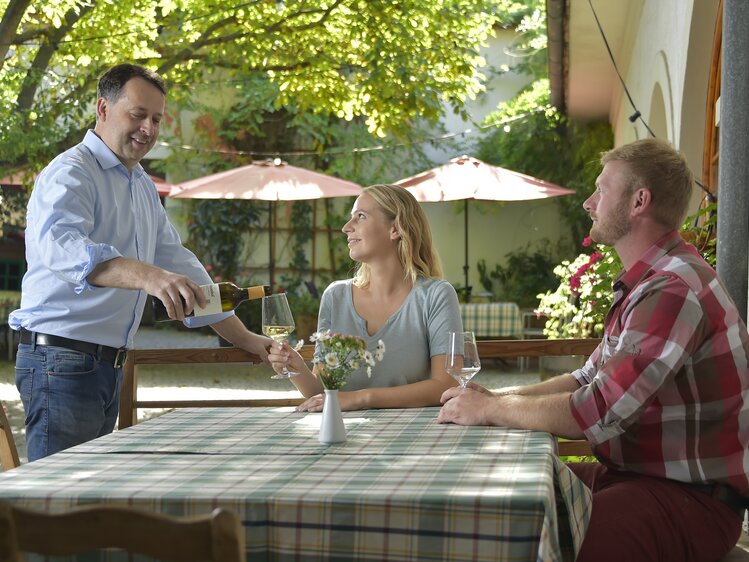 Wein einschenken beim Heurigen | © Urlaub am Winzerhof / Ralph Fischbacher