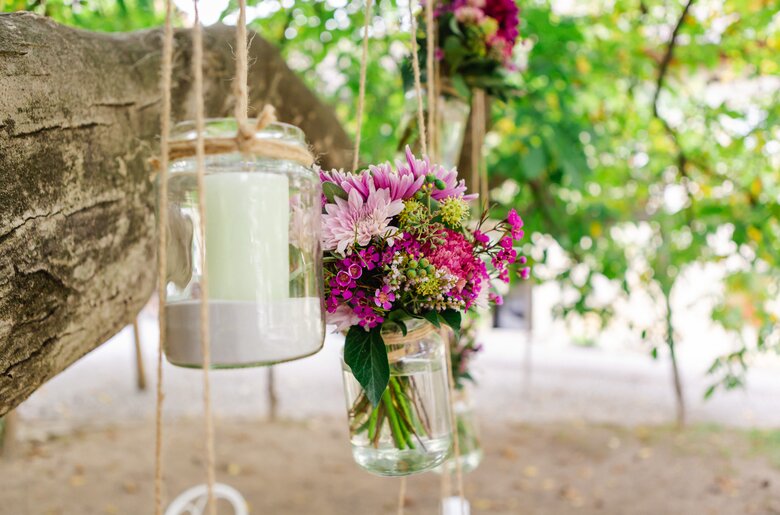 Kerzen und Blumen hängen in einem Glas am Baum | © Urlaub am Winzerhof / Marie & Michael Photography - www.marieundmichael.com