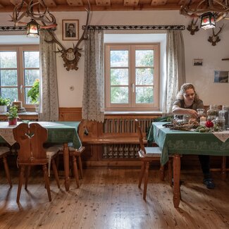 Bäuerin sitzt in traditioneller Stube mit Räucherwerk am Ferienhof Zamsegg in Vorderstoder, Nationalparkregion Kalkalpen | © Oberösterreich Tourismus GmbH / Martin Fickert