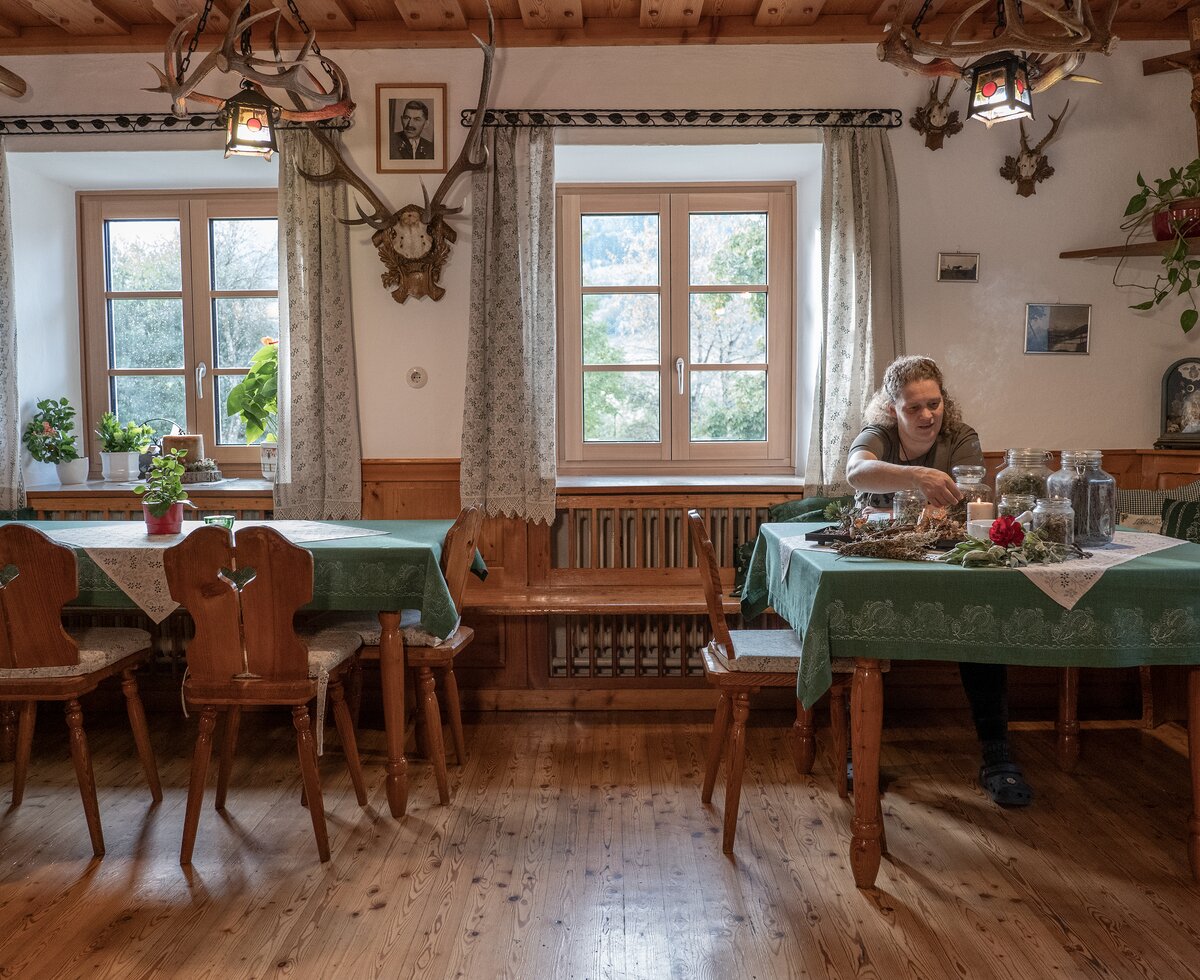 Bäuerin sitzt in traditioneller Stube mit Räucherwerk am Ferienhof Zamsegg in Vorderstoder, Nationalparkregion Kalkalpen | © Oberösterreich Tourismus GmbH / Martin Fickert