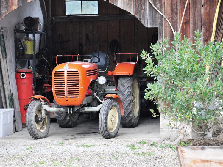 Roter Oldtimer-Traktor steht in der Garage | © Urlaub am Bauernhof Oberösterreich / Harald Puchegger