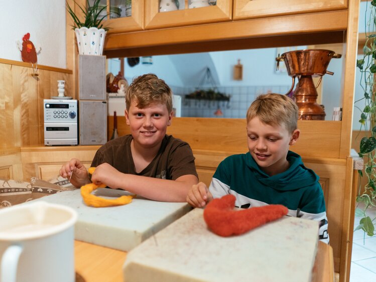 Kinder sitzen vor gefärbter Wolle beim Filzen | © Urlaub am Bauernhof Oberösterreich / Daniel Gollner