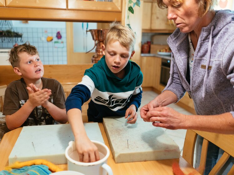 Bäuerin mit zwei Buben am Filzen | © Urlaub am Bauernhof Oberösterreich / Daniel Gollner