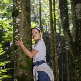 Frau lehnt beim Baum beim Waldbaden | © Urlaub am Bauernhof Oberösterreich / puremotions photography