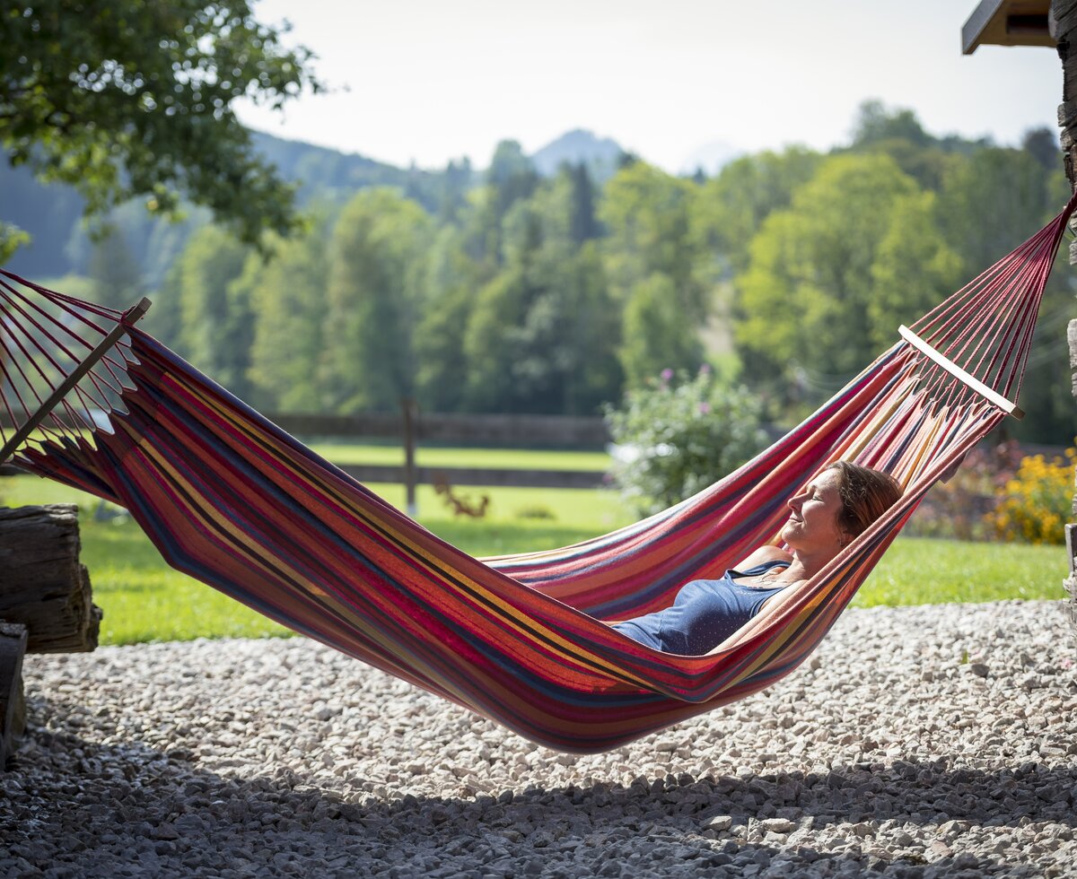 Frau liegt in der Hängematte und entspannt sich in der Sonne | © Urlaub am Bauernhof Oberösterreich / Andreas Hofer