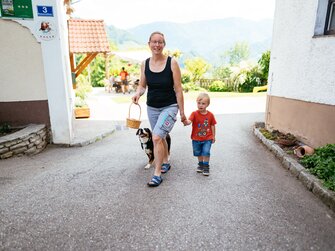 Mama geht mit Hund und Kind am Bauernhof spazieren | © Urlaub am Bauernhof Oberösterreich / Daniel Gollner