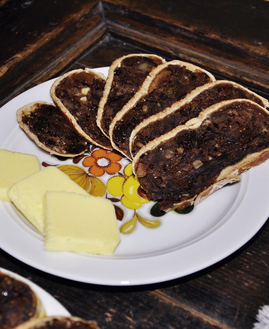 Auf dem Teller sind Scheiben frisch gebackenes Kletzenbrot mit zarter Butter angerichtet. | © Urlaub am Bauernhof Oberösterreich / Harald Puchegger