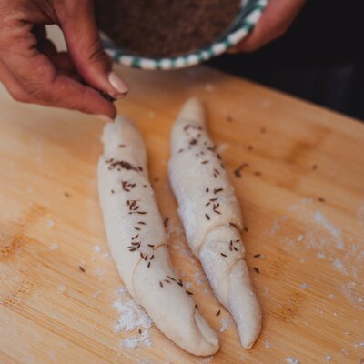 Salzstangerl mit Salz und Kümmel bestreuen | © Footprints Fotografie // cookingCatrin Salzstangerl mit Salz und Kümmel bestreuen | © Footprints Fotografie // cookingCatrin