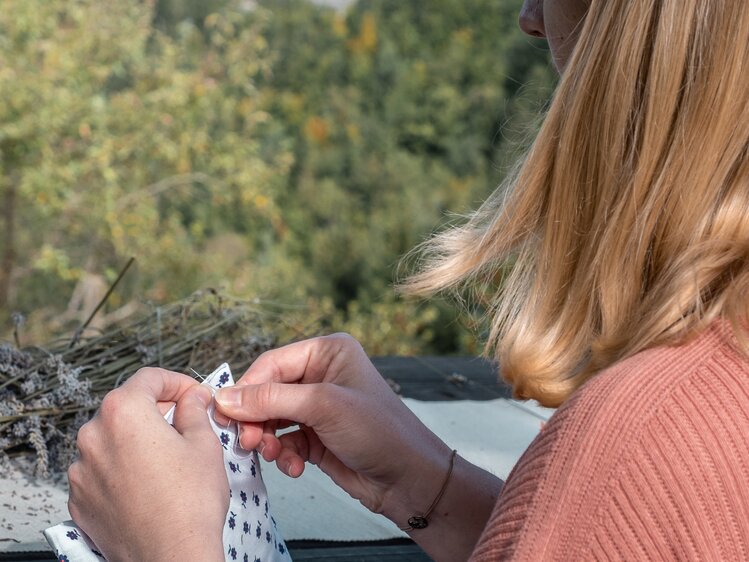 Frau näht ein Kräutersackerl zusammen | © Urlaub am Bauernhof Oberösterreich / Viktoria Urbanek