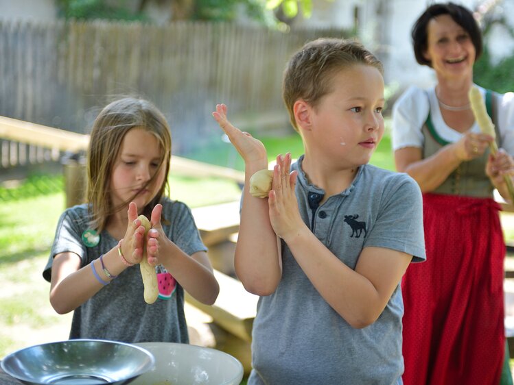 Kinder und Bäuerin machen Stockbrot | © Urlaub am Bauernhof Oberösterreich / Ralph Fischbacher