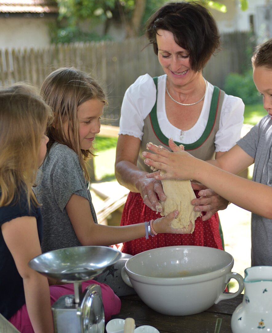 Bäuerin Anneliese Stockinger macht Stockbrot mit Kindern | © Urlaub am Bauernhof Oberösterreich / Ralph Fischbacher