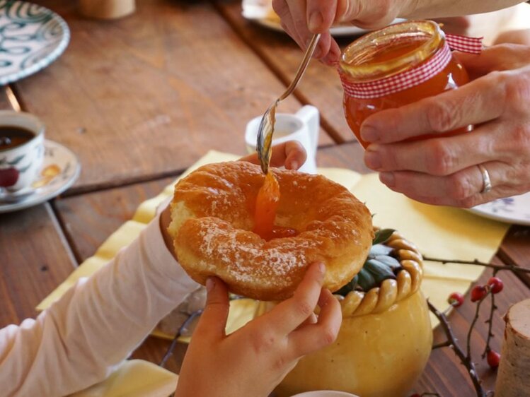 Ein Bauernkrapfen wird mit Marillenmarmelade gefüllt. | © Urlaub am Bauernhof Österreich