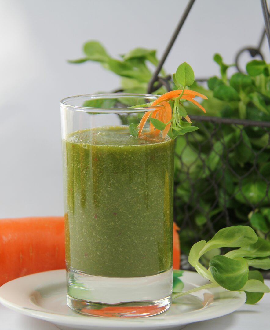 Karotten-Spinat-Smoothie im Glas mit einer Dekoration aus frischem Feldsalat und Karotten | © Urlaub am Bauernhof Oberösterreich