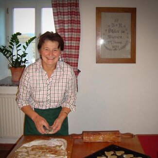 Bäuerin sticht Mostherzen aus und legt sie auf das Backblech. | © Urlaub am Bauernhof Oberösterreich / Karoline Rabengruber