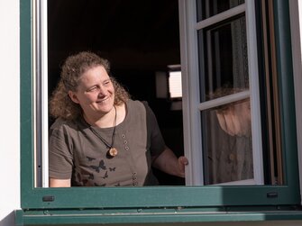 Bäuerin schaut beim Fenster heraus | © Oberösterreich Tourismus GmbH / Martin Fickert