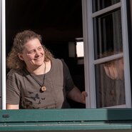 Bäuerin schaut beim Fenster heraus | © Oberösterreich Tourismus GmbH / Martin Fickert