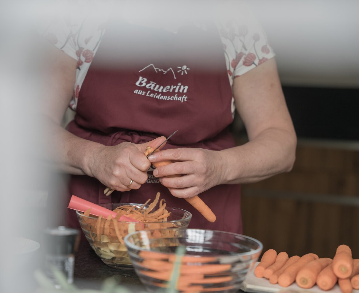 Frau schneidet Karotten | © Urlaub am Bauernhof / Daniel Gollner