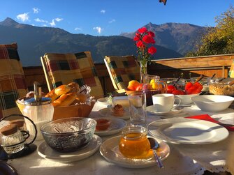 Frühstückstisch im Freien mit Bergen im Hintergrund | © Antje Zimmermann / Urlaub am Bauernhof