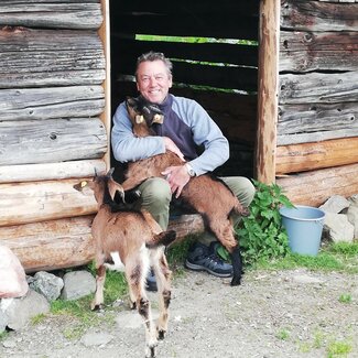 Mann umarmt Ziegen | © Urlaub am Bauernhof Österreich