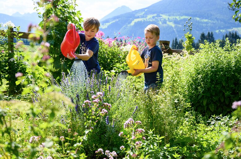 Zwei Buben gießen den Garten mit zwei Gießkannen | © Katja Stadler / Urlaub am Bauernhof