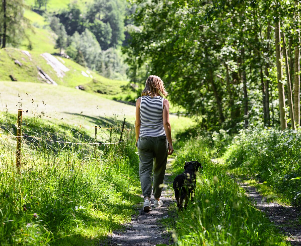 Frau geht mit Hund spazieren | © Urlaub am Bauernhof / Punkt und Komma