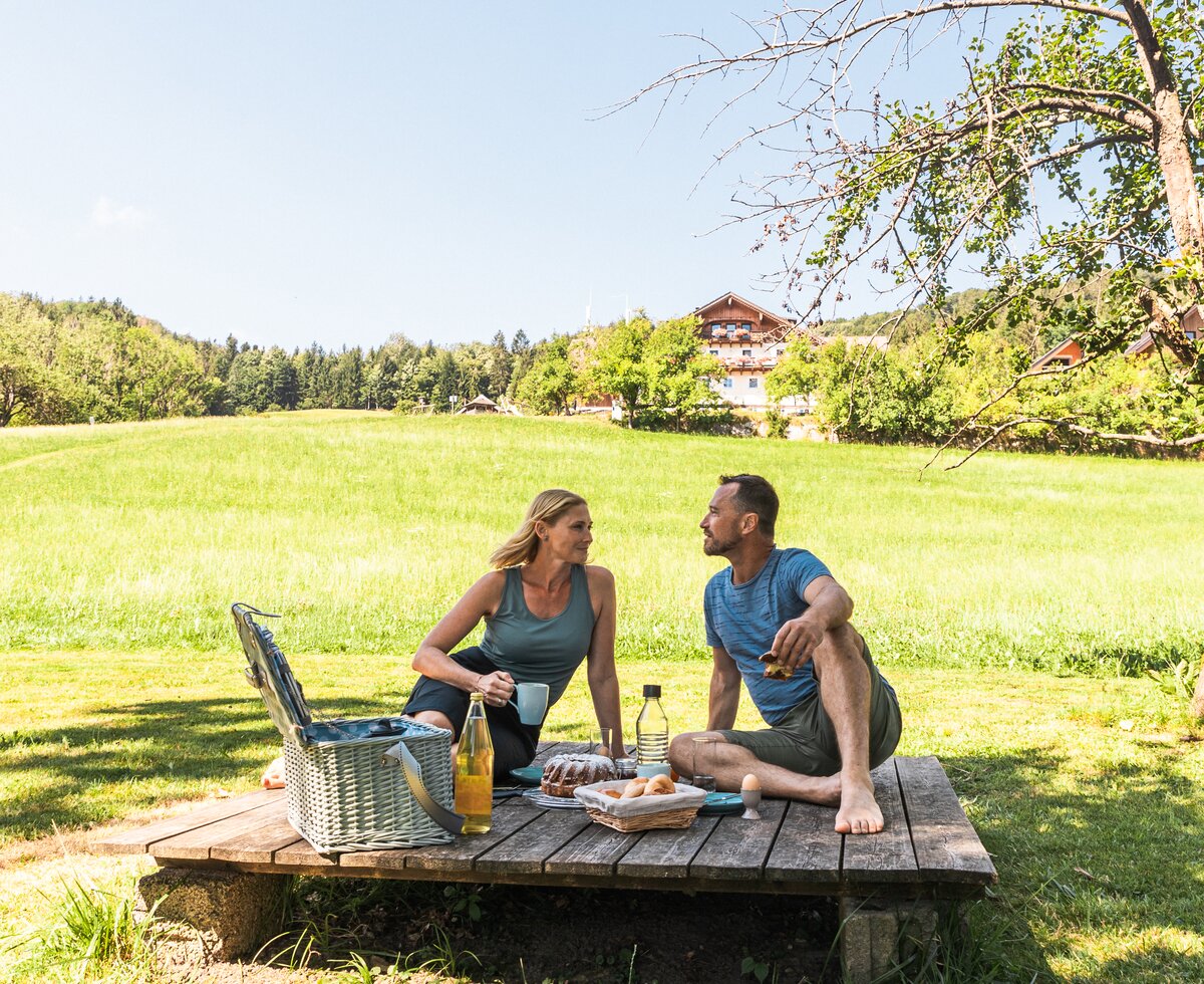 Ein Paar macht ein Picknick im Garten | © Urlaub am Bauernhof / Punkt und Komma