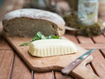 Bauernbrot und Almbutter liegen auf einem Holzbrett. | © Urlaub am Bauernhof im SalzburgerLand / Matthias Gruber