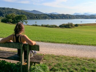 Frau sitzt auf einer Bank und genießt den Seeblick. | © Urlaub am Bauernhof im SalzburgerLand / www.travelpins.at