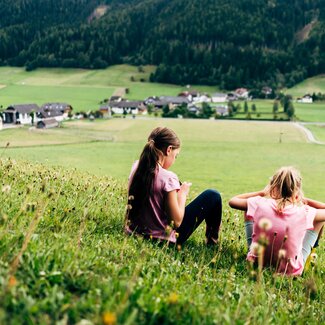 Zwei Mädchen sitzen in der Wiese | © Urlaub am Bauernhof im SalzburgerLand / Daniel Gollner