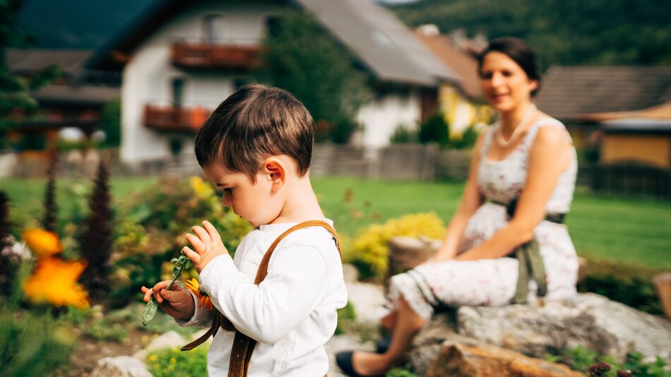 Bub spielt unter der Aussicht seiner Mutter im Kräutergarten. | © Urlaub am Bauernhof im SalzburgerLand / Daniel Gollner