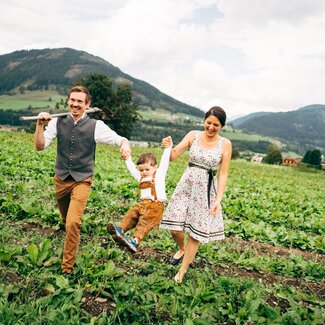 Familie Löcker geht über den Kartoffelacker. | © Urlaub am Bauernhof im SalzburgerLand / Daniel Gollner