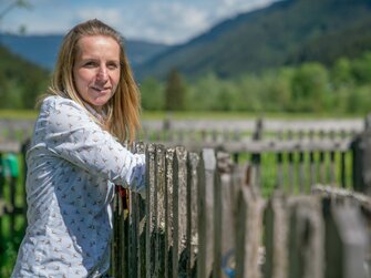 Sabine Grünwald vom Loitzhof in Untertauern lehnt am Gartenzaun. | © Urlaub am Bauernhof im SalzburgerLand / Matthias Gruber