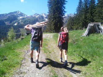 Bauer und Bäuerin tragen das Material für den neuen Zaun auf die Alm. | © Biohof Maurachgut / Familie Schuster